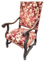 A European walnut C17th style open armchair with upholstered rectangular back and seat flanked by