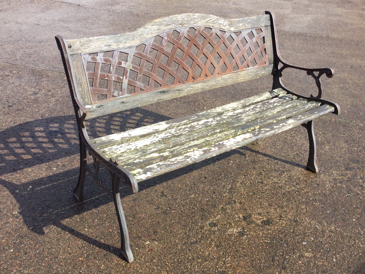 A garden bench with arched latticework panel to back above a wood slatted seat, raised on sabre legs - Image 3 of 3