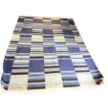 A contemporary wool kelim carpet woven with striped bands in shades of blue. (96in x 68in)