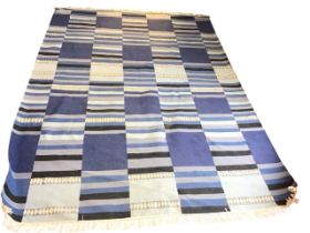 A contemporary wool kelim carpet woven with striped bands in shades of blue. (96in x 68in)