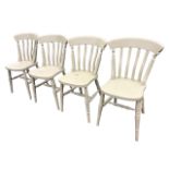 A set of four painted slatback chairs with solid dished seats raised on turned tapering legs
