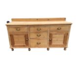 A Victorian pine dresser with rectangular moulded top having three frieze drawers above two