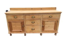 A Victorian pine dresser with rectangular moulded top having three frieze drawers above two