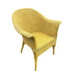 A Lloyd Loom style wicker tub chair, the arched back and arms above curved rectangular seat,