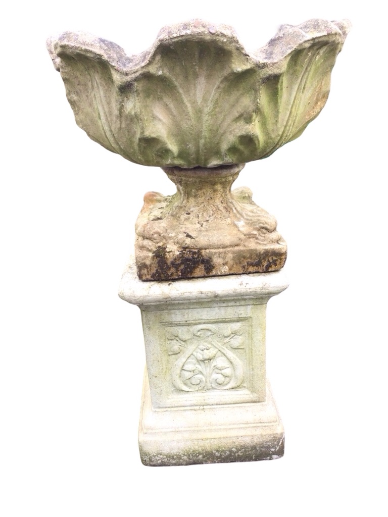 A composition stone garden urn on stand, with scalloped leaf moulded pot on square base with