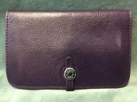 A Hermès purple leather wallet with metal closure and two compartments, having removable matching