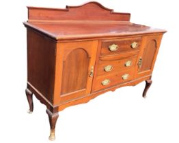 An Edwardian mahogany sideboard with arched raised back above a bowfronted top and three drawers,