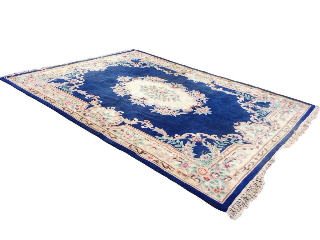 A rectangular Chinese aubusson style rug with central floral medallion on a deep blue ground