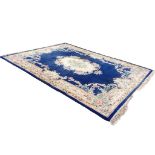 A rectangular Chinese aubusson style rug with central floral medallion on a deep blue ground