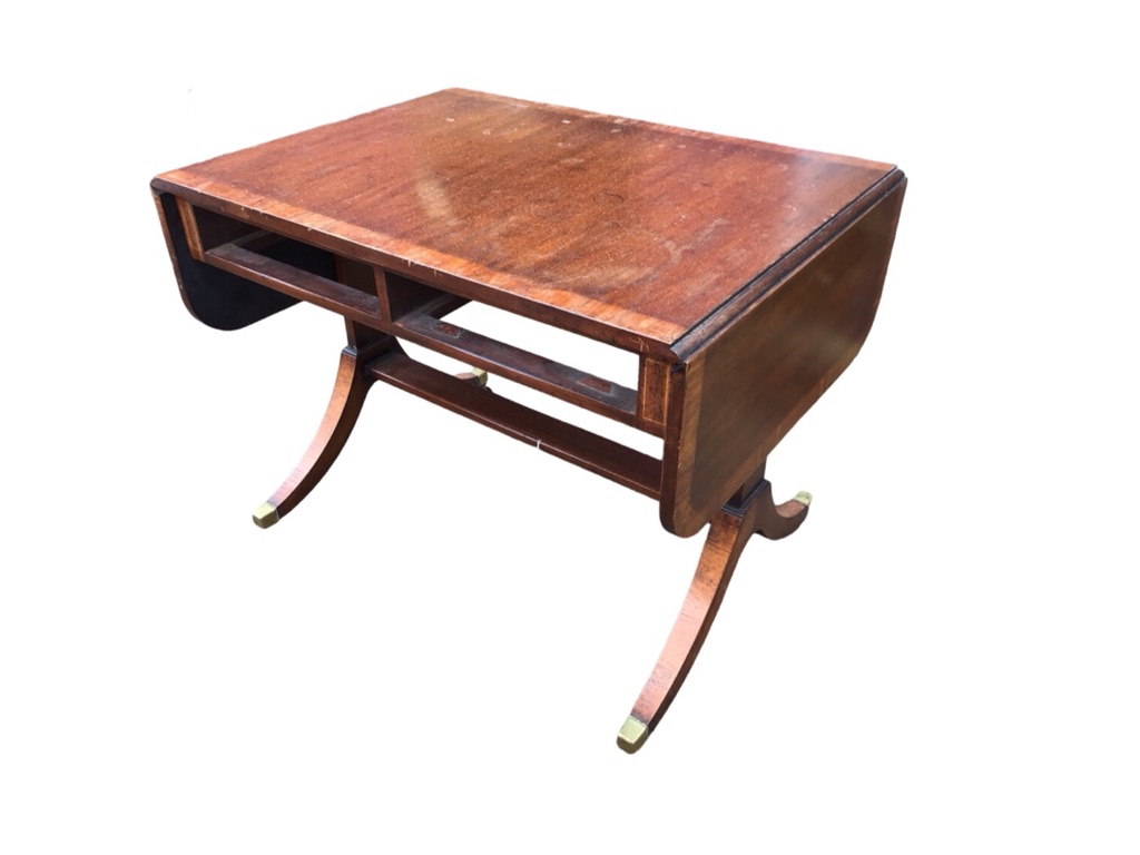 A crossbanded mahogany sofa table with rounded drop-ends raised on rectangular supports with sabre