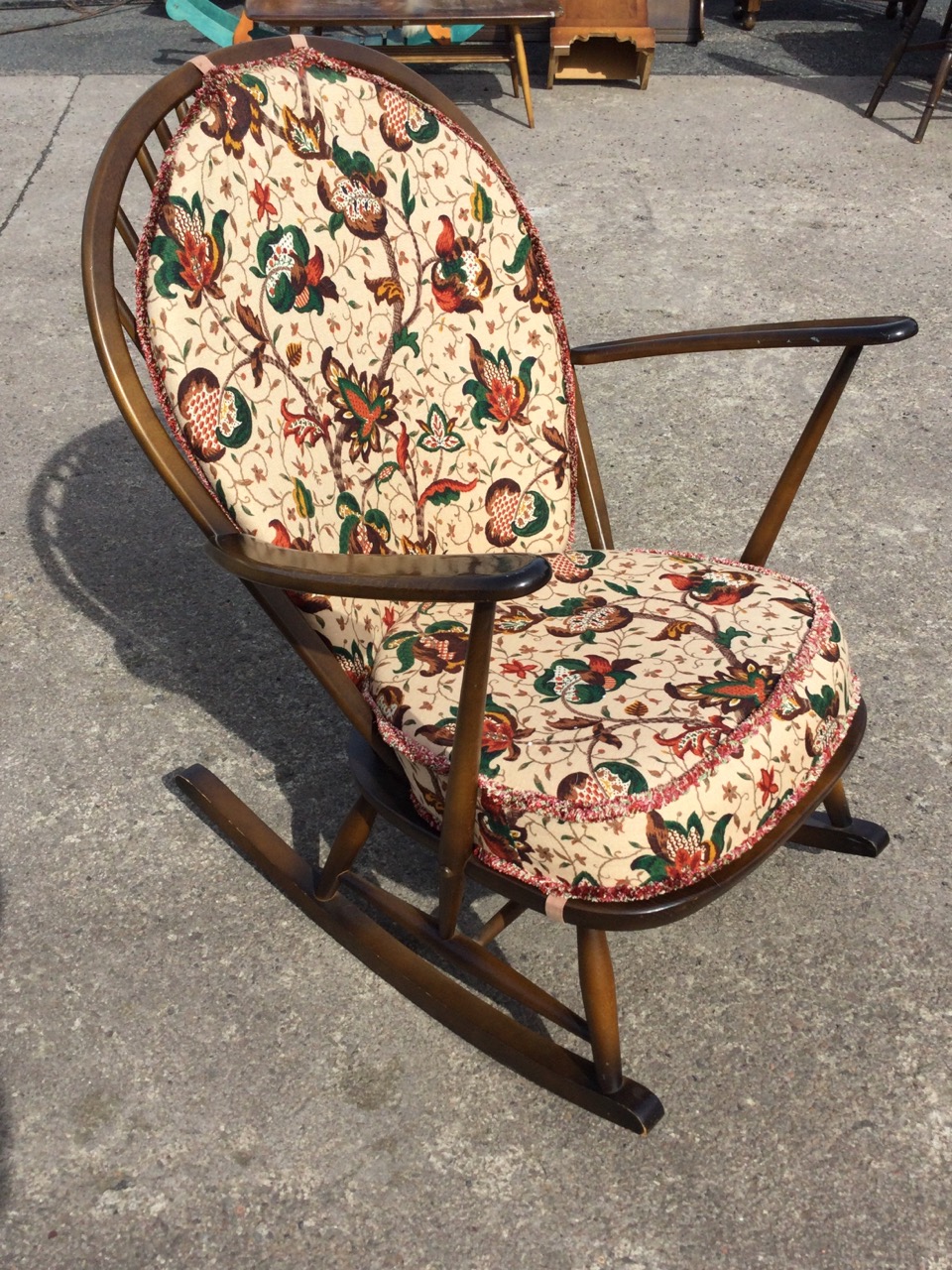 An Ercol elm & beech rocking chair with hooped spindle back and solid seat with loose cushions