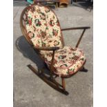 An Ercol elm & beech rocking chair with hooped spindle back and solid seat with loose cushions
