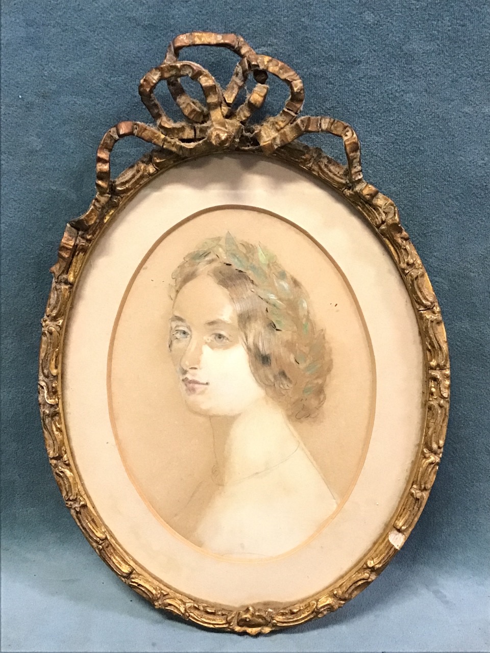 A mid-Victorian oval watercolour bust portrait of a young lady wearing a laurel wreath, mounted,