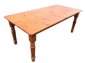 A 6ft pine kitchen table with rectangular top on turned tapering legs. (35.5in x 72.5in x 29.5in)