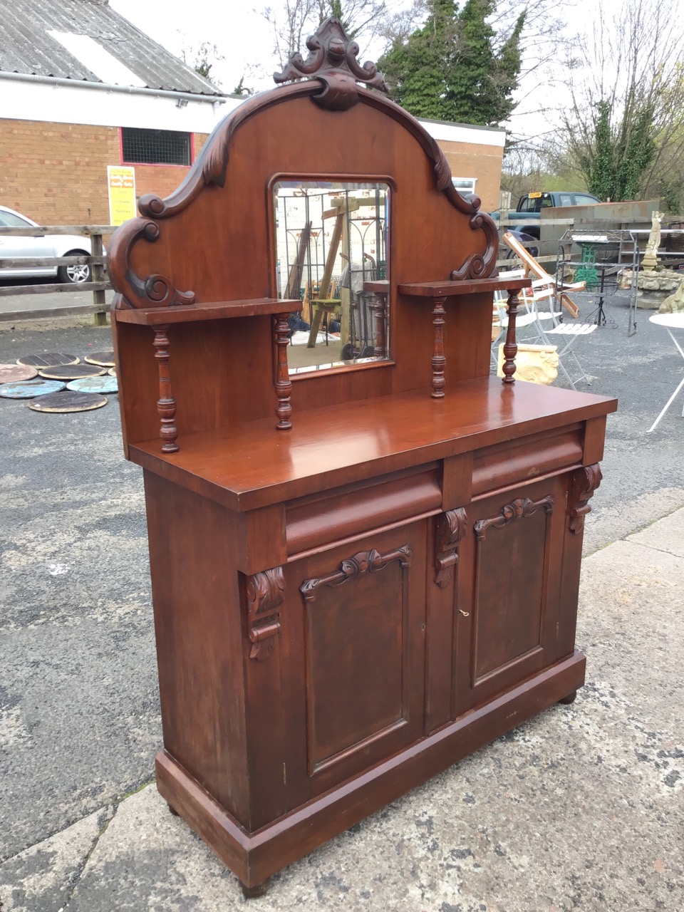 A Victorian mahogany chiffonier with arched scroll carved back having central mirror flanked by