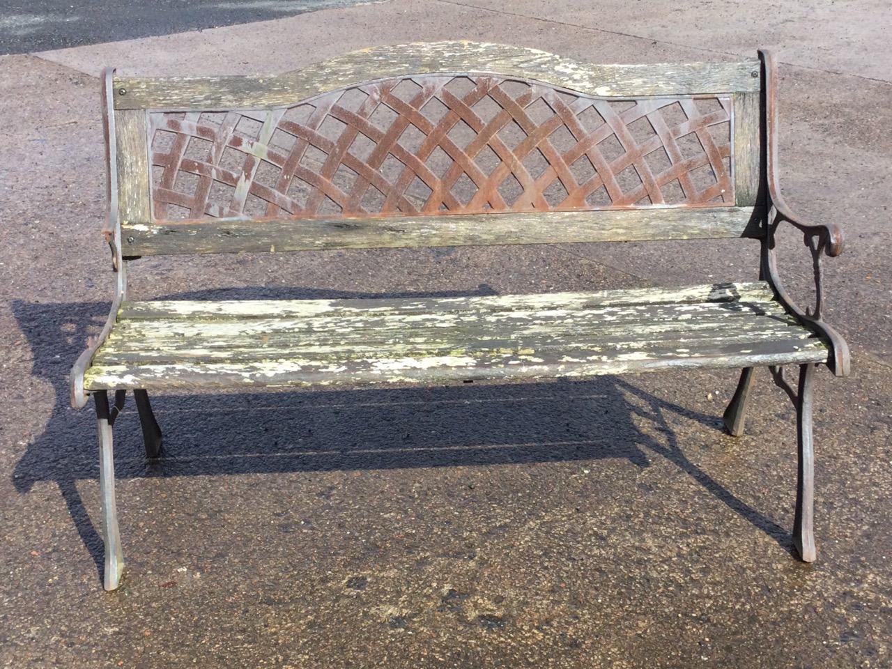 A garden bench with arched latticework panel to back above a wood slatted seat, raised on sabre legs - Image 2 of 3