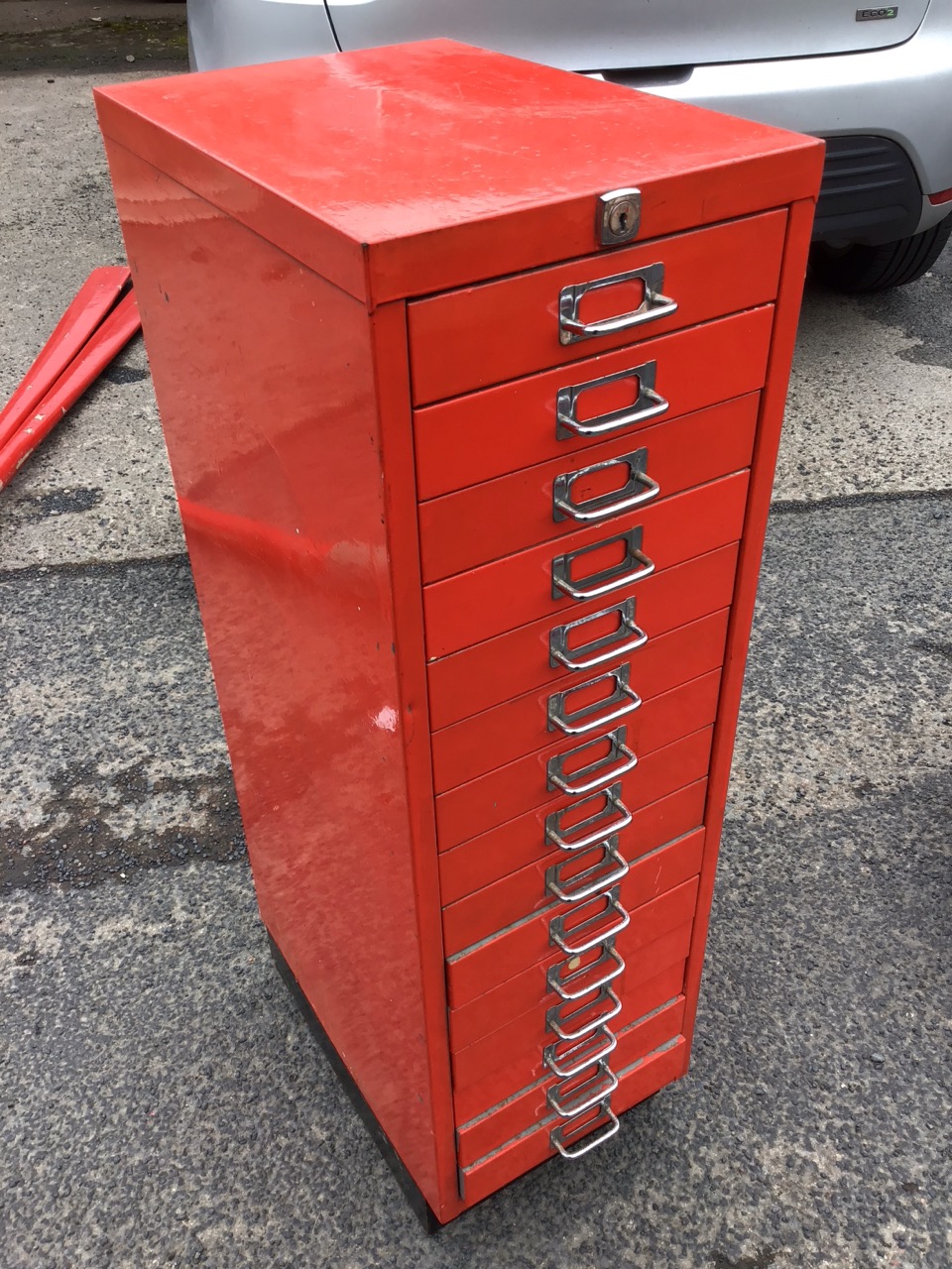 A painted metal collectors cabinet of fifteen drawers mounted with chromed label loop handles, on