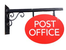 A contemporary oval metal post office sign on scrolled bracket with rectangular wallplate. (32.5in)