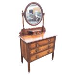 An Edwardian oak dressing table with circular bevelled mirror on baluster turned columns with
