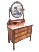 An Edwardian oak dressing table with circular bevelled mirror on baluster turned columns with