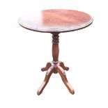 A circular stained pine occasional table with moulded top on turned column with quadripartite shaped