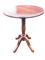 A circular stained pine occasional table with moulded top on turned column with quadripartite shaped