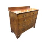 An Edwardian mahogany chest of drawers, with low back to the moulded top above two short & three