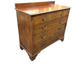An Edwardian mahogany chest of drawers, with low back to the moulded top above two short & three