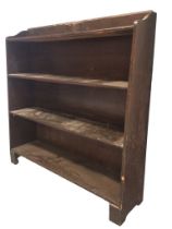 A 30s oak bookcase with raised back applied with a deco carved plaque, above four shelves raised