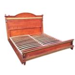 A mahogany Empire style bed, the headboard with arched cornice and turned finials above a gilded