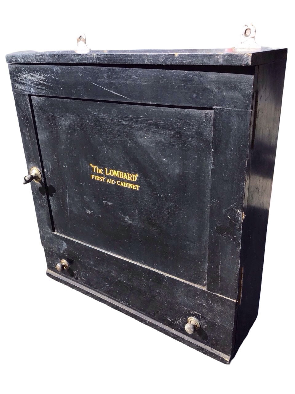 An Edwardian hanging ebonised first aid cabinet - The Lombard, with brass knobbed panelled door
