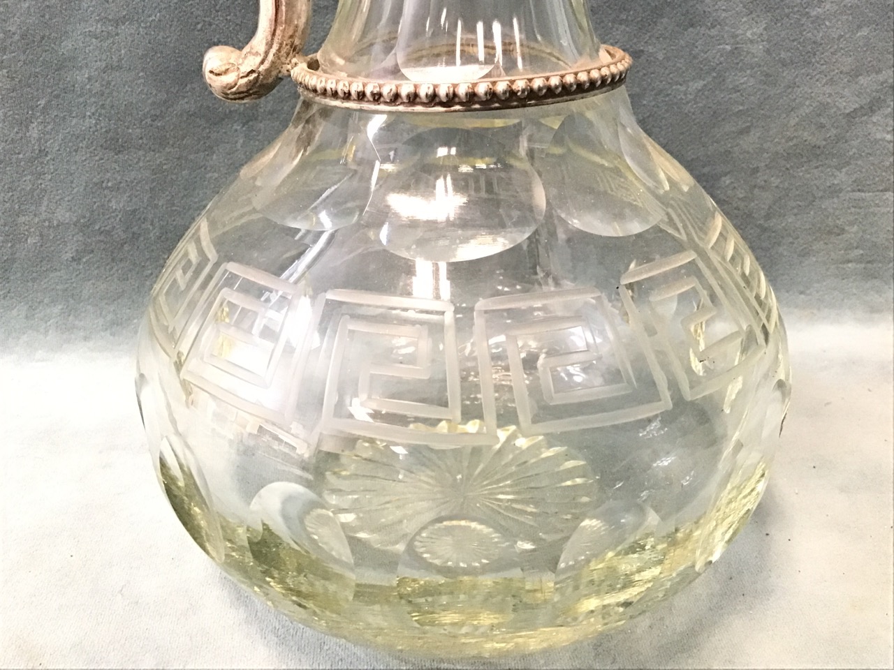 A cut glass globular claret jug with porthole and greek key motifs, having floral engraved silver - Image 3 of 3