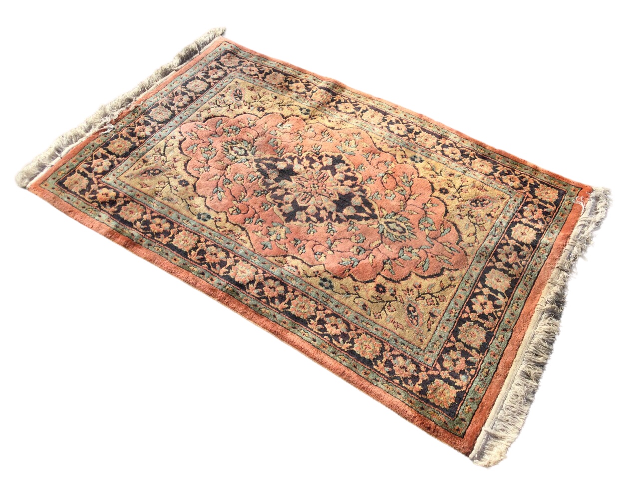 An oriental style wilton rug woven with central scalloped pink floral medallion on fawn field, the