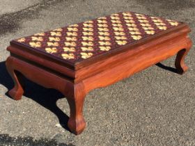 A mahogany low stool with woolwork fleur-de-lys tapestry upholstered seat above moulded rails and