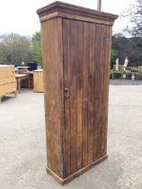 A Victorian tongue & grooved pine cupboard with hinged door enclosing shelves beneath a moulded