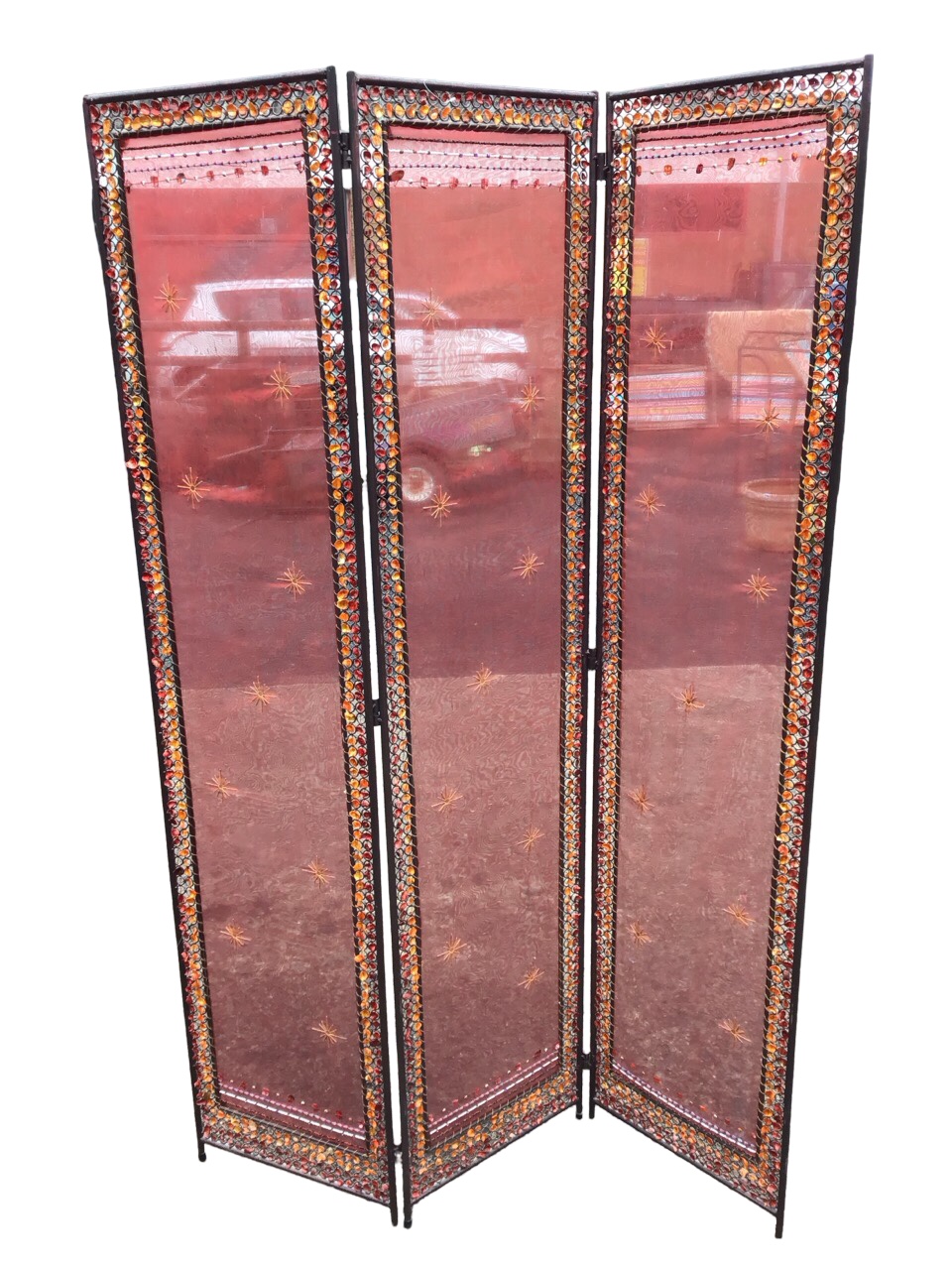 An Indian three-fold wrought iron screen with organza panels embroidered with stars and beaded bands