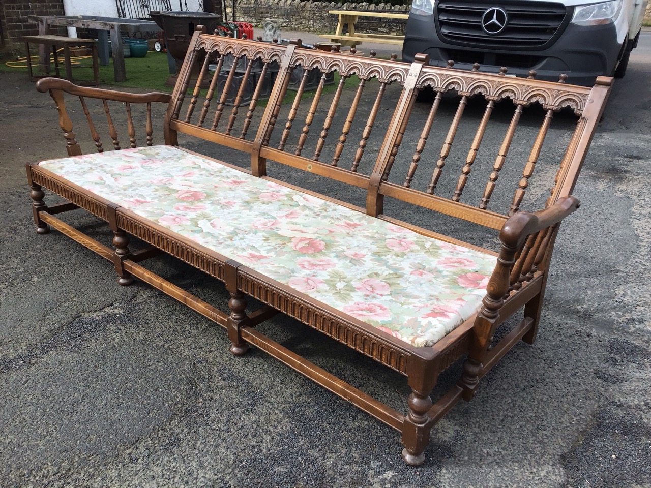 An Ercol elm Old Yorkshire pattern three-seater sofa with turned spindle back with carved