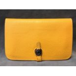 A yellow leather Hermès wallet with double pouch & removable purse, having metal fastening.