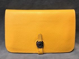 A yellow leather Hermès wallet with double pouch & removable purse, having metal fastening.