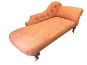 A Victorian style upholstered chaise longue with buttoned shaped back and outscrolled arm above a