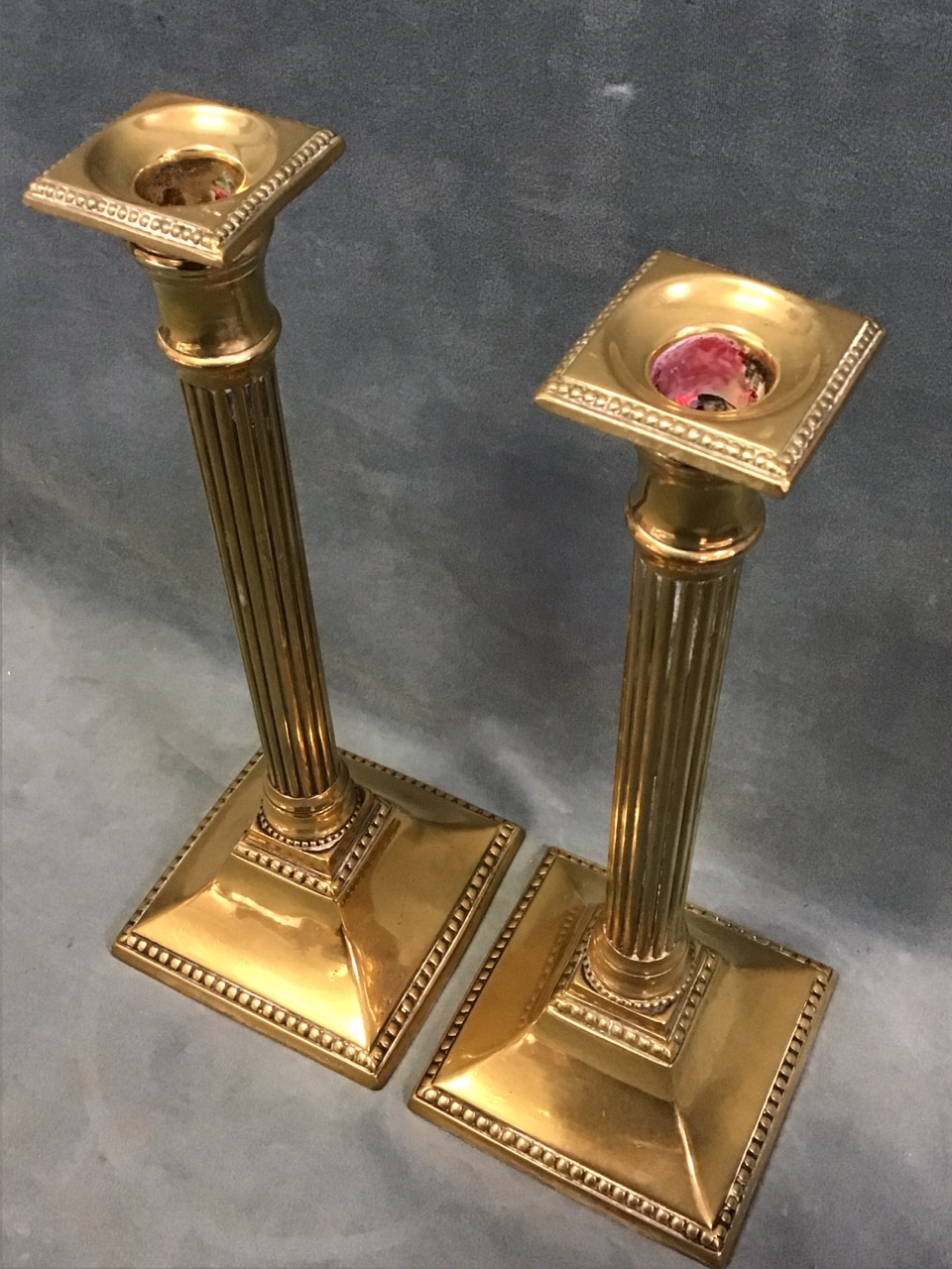 A pair of Georgian brass candlesticks with square beaded sconces above reeded Tuscan columns on - Image 2 of 3