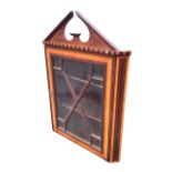 A Victorian mahogany hanging corner cabinet with broken pediment and chequered cornice above an