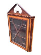 A Victorian mahogany hanging corner cabinet with broken pediment and chequered cornice above an