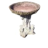 A composition stone birdbath of moulded log form, with circular bowl on treetrunk mounted with