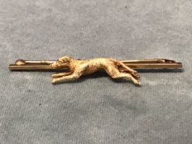 A 9ct gold stock pin with a finely modelled running greyhound. (2.25in) (5g)