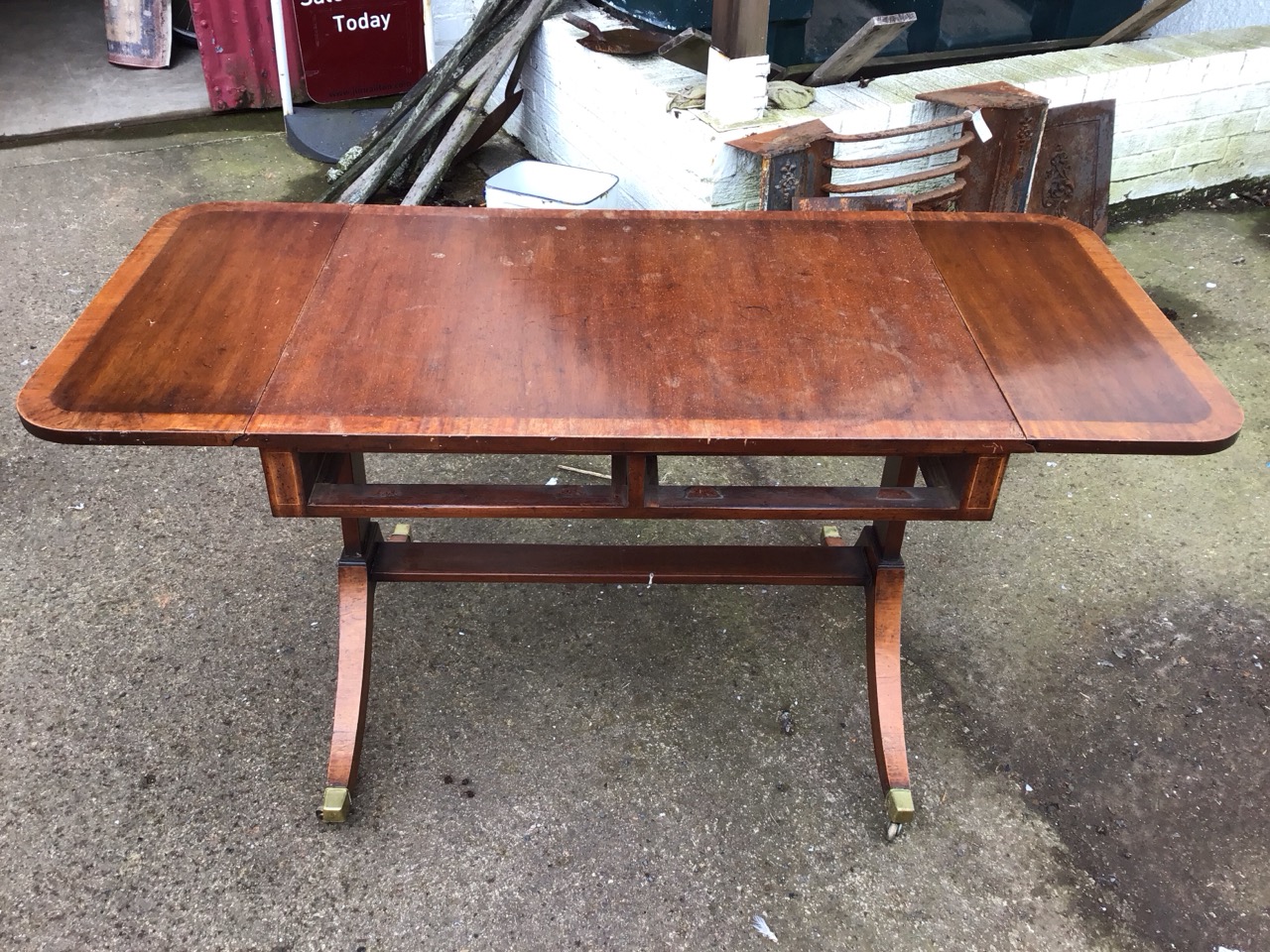 A crossbanded mahogany sofa table with rounded drop-ends raised on rectangular supports with sabre - Image 2 of 3