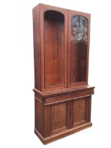 A Victorian mahogany bookcase, with two arched panelled doors enclosing space for shelves, above a
