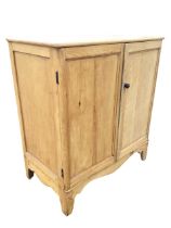 A Victorian pine cupboard with moulded panelled doors above a shaped apron, raised on bracket