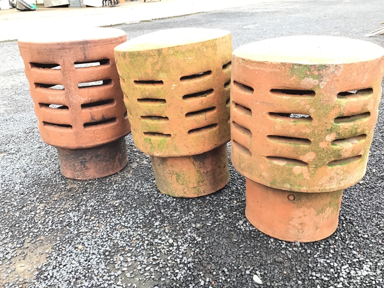 Three terracotta chimney cowls of tubular form with domed tops above slit-vented bodies. (13.5in) ( - Image 3 of 3