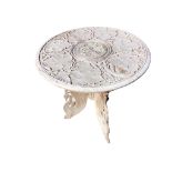 A circular carved oriental occasional table with moulded top having leaf frieze framing inlaid